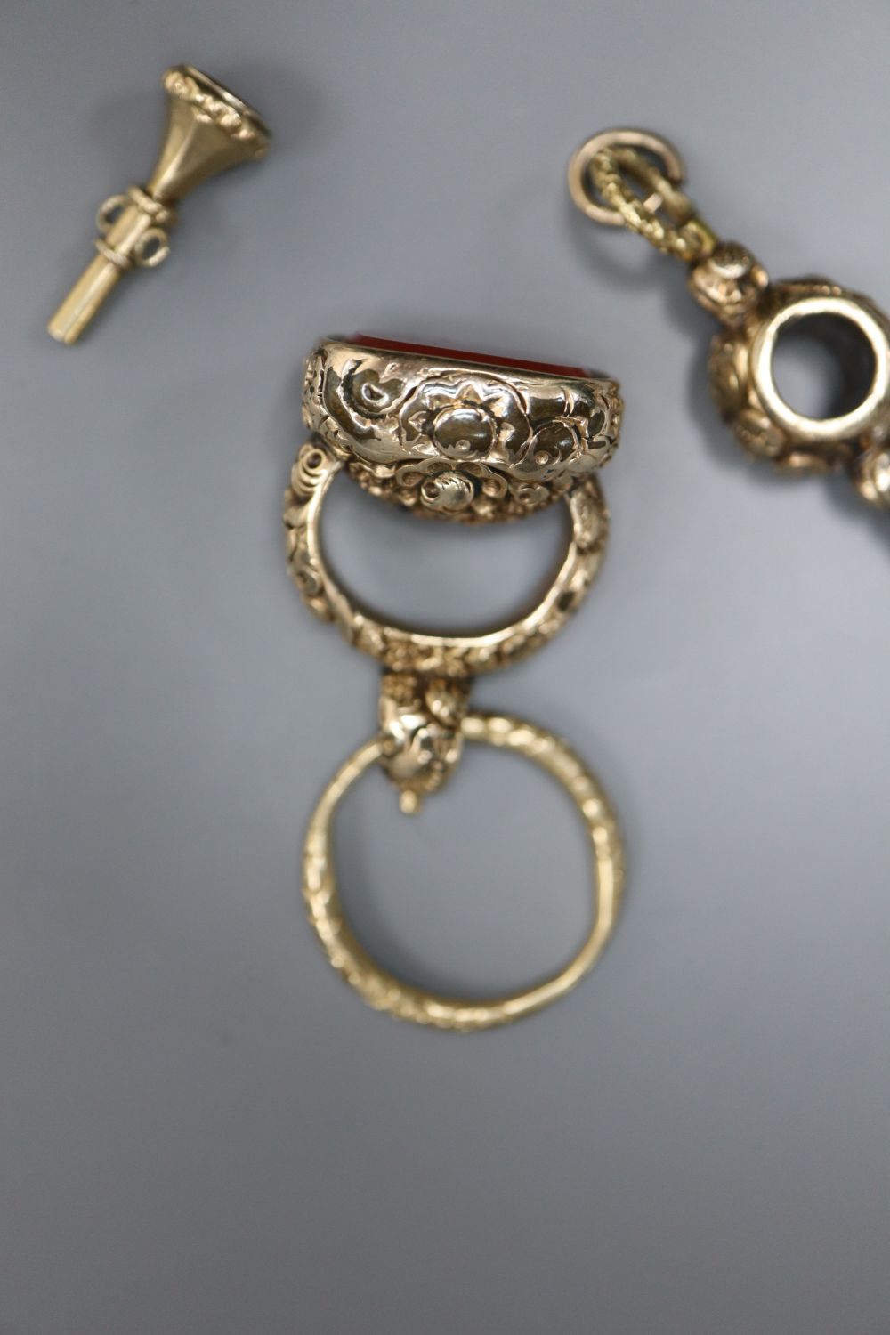 A 19th century gold-cased fob seal with uncut carnelian matrix, a 19th century gold watch key and a gold-cased watch key